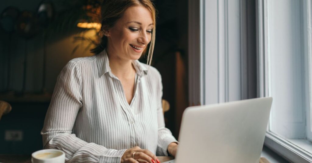 A virtual assistant sitting on a desk with laptop.